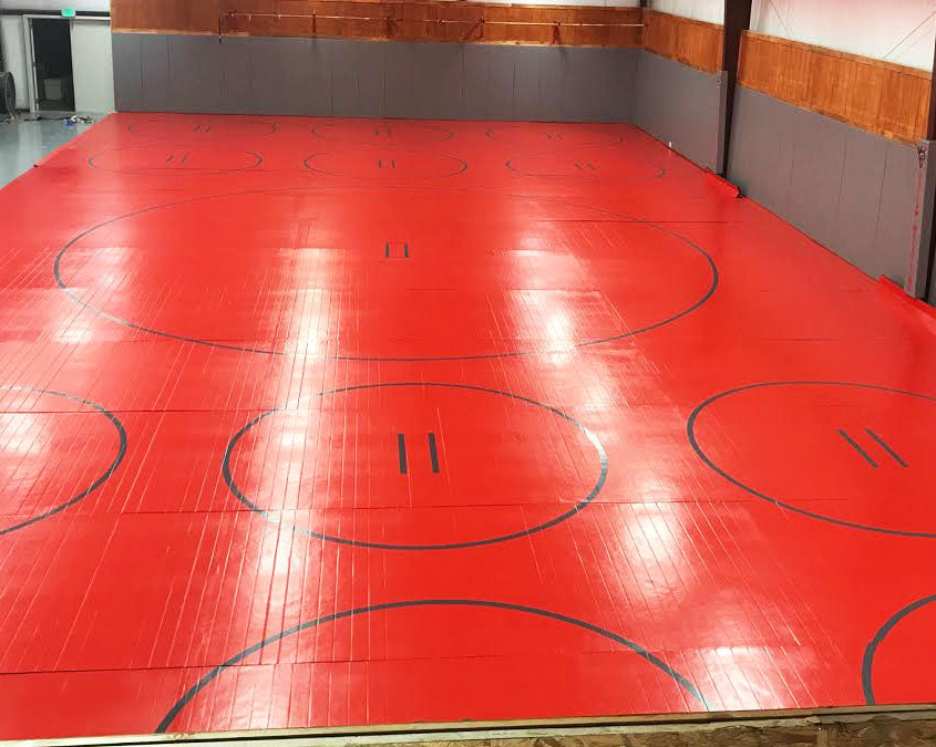 High School Wrestling Room with Red and Gray Competition Wrestling Mat and Practice Circles for Drills