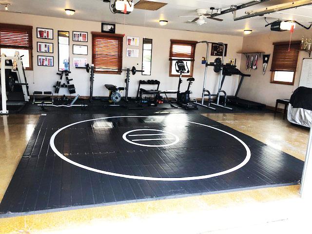 Black wrestling mat in workout garage. AK Athletics wrestling mats are great for home use, personal gyms and workout facilities.