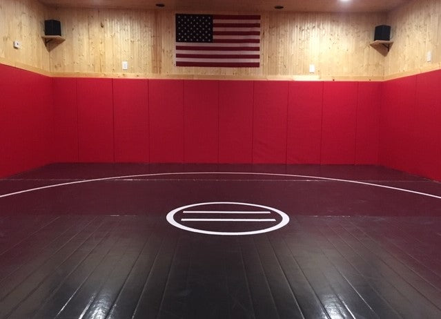 Home wrestling room black mat with red wall pads. Mats for custom rooms, facilities businesses, training and personal use.