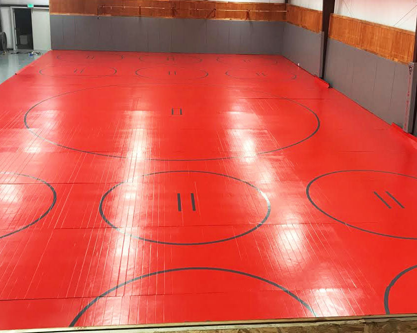High School Wrestling Room with Red and Gray  Competition Wrestling Mat and Practice Circles for Drills 