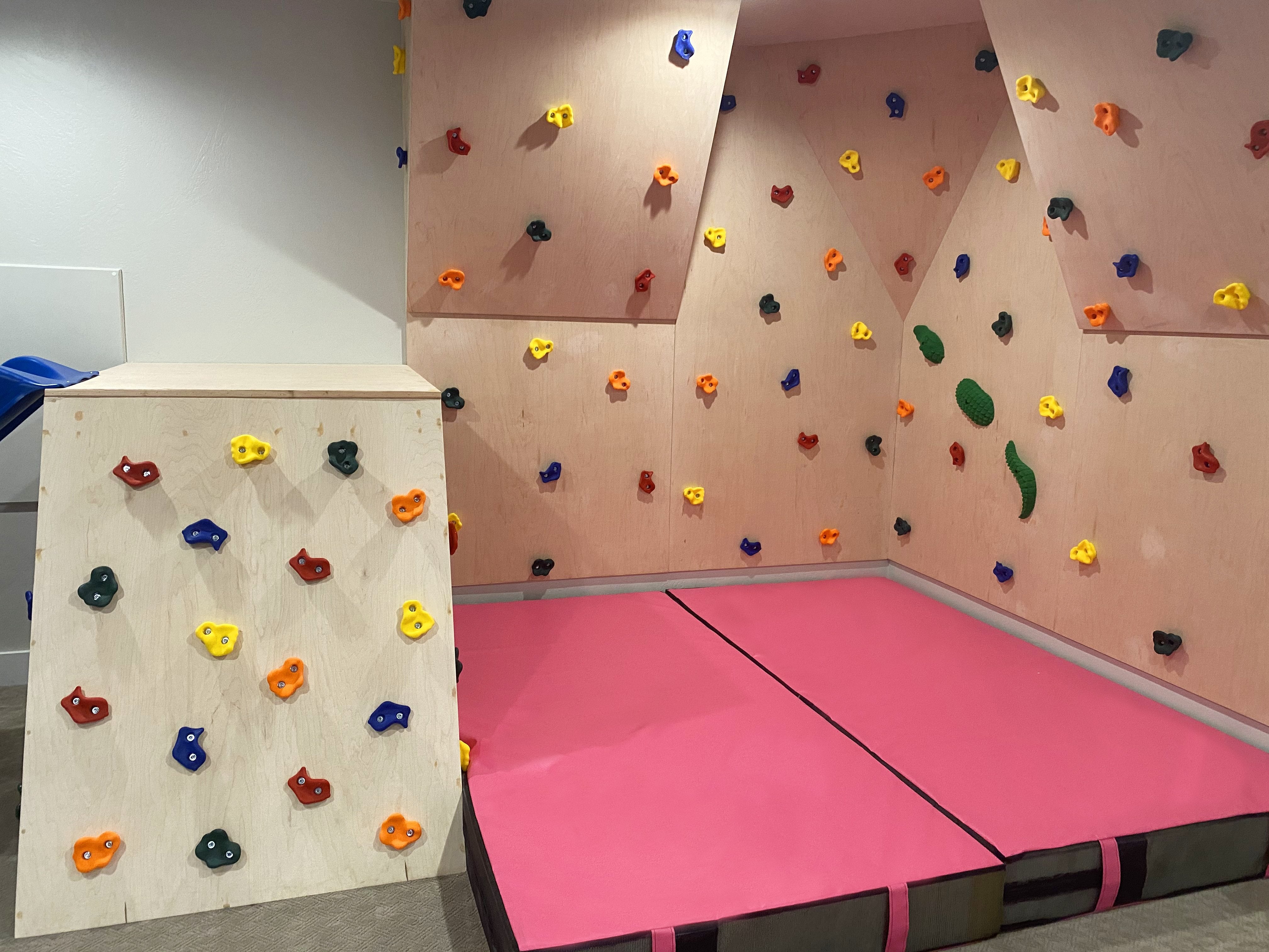 Pink crash mat under rock climbing wall 